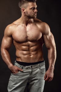 Strong Athletic Man Fitness Model Torso showing big muscles over black background